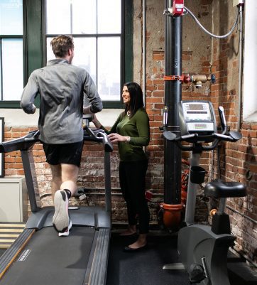 woman talking to man on treadmill