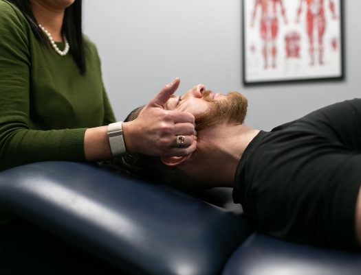 man receiving therapy on neck