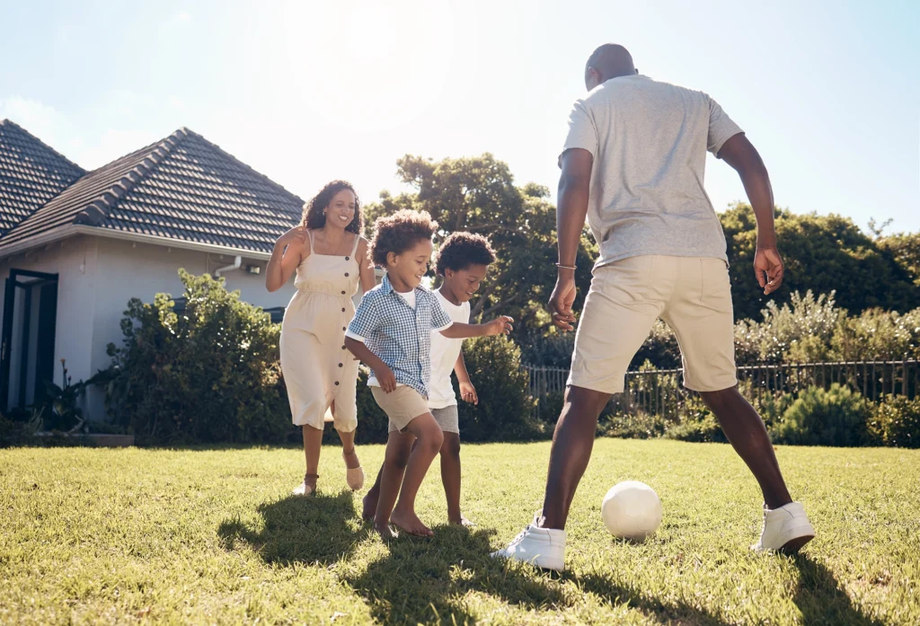 Adults playing five-a-side soccer in a Boston park in summer